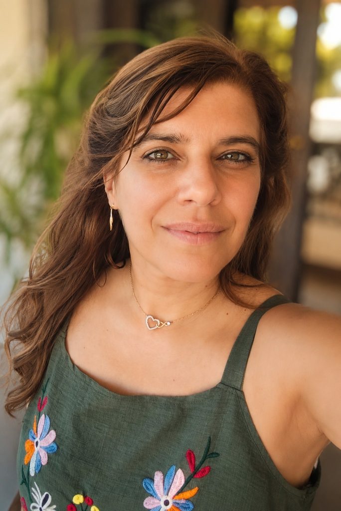 Retrato da fundadora da AKSHARA ao ar livre, rodeada pela natureza.