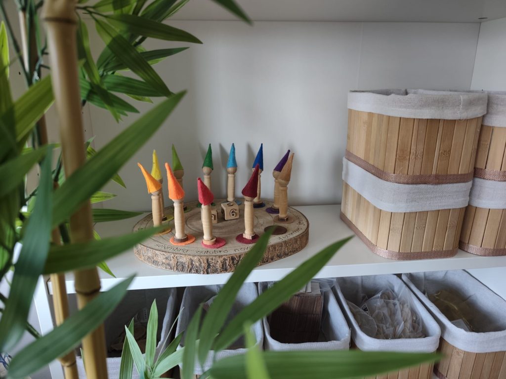Detalhe do ateliê AKSHARA com plantas e peças artesanais em madeira.